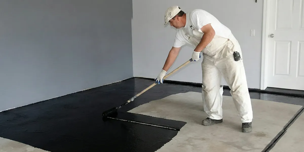 basement waterproofing professional applying waterproof coating to protect a basement floor in Las Vegas, NV